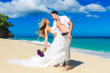 Fototapeta na wymiar happy bride and groom having fun on a tropical beach