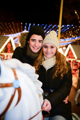 happy young couple having fun in a merry-go-round in winter