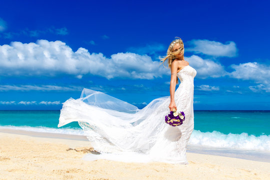 beautiful blond fiancee in white wedding dress with big long whi