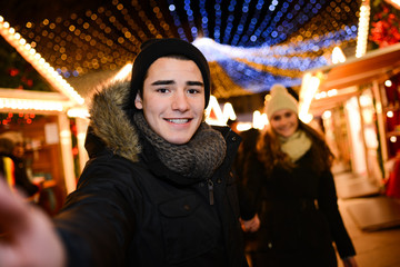 happy young couple having fun downtown at night during winter