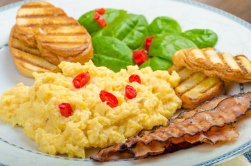Scrambled eggs with toast and fresh salad