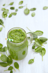 Apple and spinach smoothie in glass on a wooden background