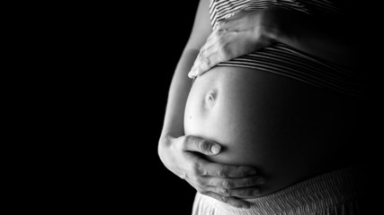 Pregnant belly over black background