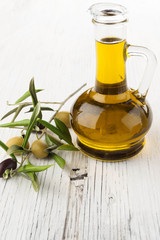 Olive oil and olive branch on the wooden table
