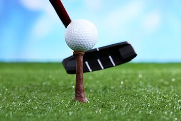 Golf ball and driver on green grass outdoor close up