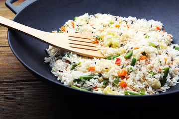 Tasty rice preparing in wok, close-up