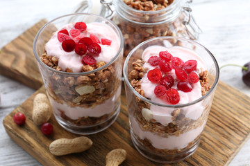 Healthy layered dessert with muesli and berries on table