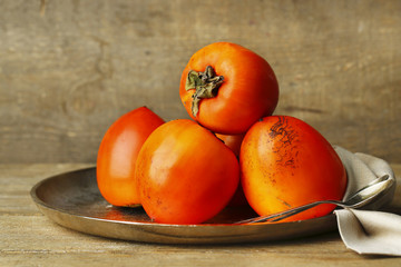 Ripe sweet persimmons, on wooden table
