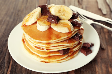 Stack of delicious pancakes with chocolate, honey and slices of