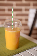 Orange juice in fast food closed cup with tube