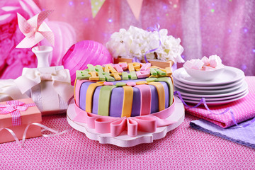 Delicious birthday cake on table on bright background