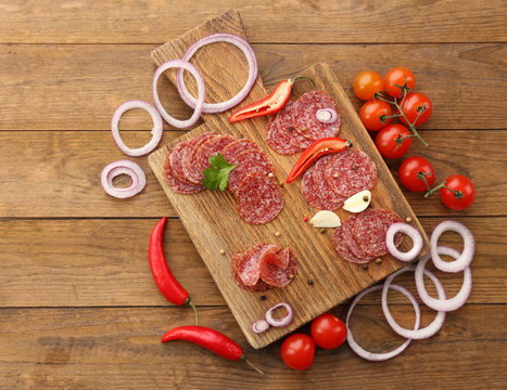 Slices of salami with spices and vegetables