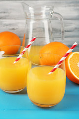 Glass of orange juice with straws and slices