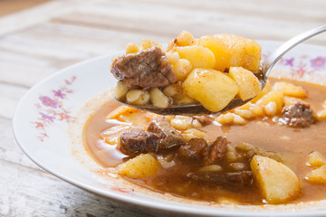 Traditional Hungarian goulash on spoon, closeup