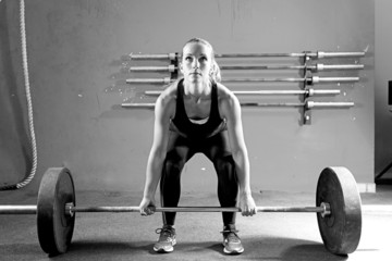 young woman on a weightlifting session - crossfit workout.