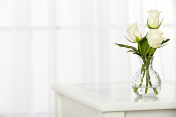 Beautiful bouquet of flowers in vase on window background