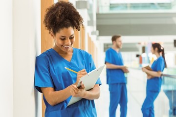 Medical student taking notes in hallway