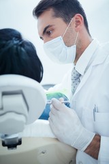 Fototapeta na wymiar Male dentist examining womans teeth