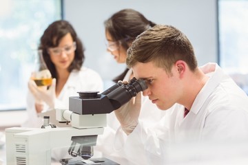 Fototapeta na wymiar Science student looking through microscope in the lab