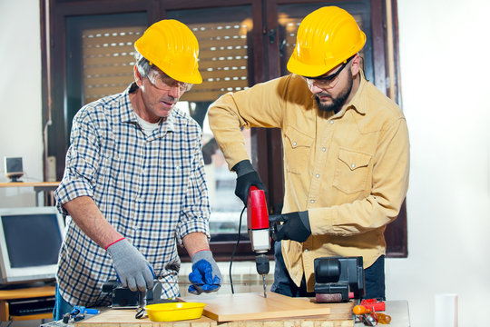 Craftsmen use an electric drill