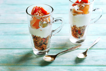 Healthy layered dessert with muesli and strawberries on table