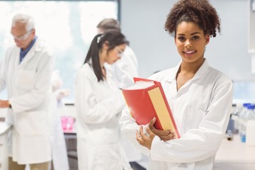Fototapeta premium Science student holding large folder in lab