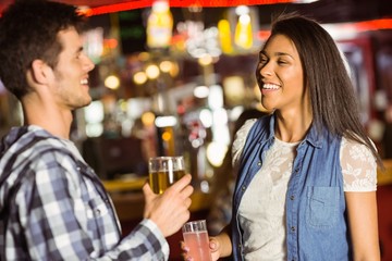 Smiling friends drinking beer and mixed drink