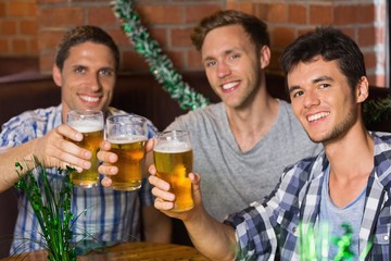 Happy friends toasting with pints of beer on patricks day