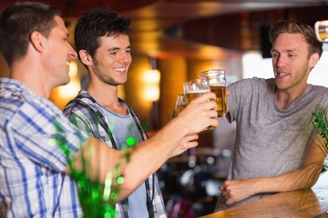 Happy friends toasting with pints of beer on patricks day