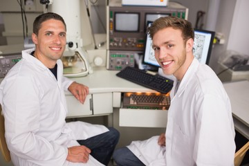 Fototapeta premium Biochemistry student using large microscope and computer