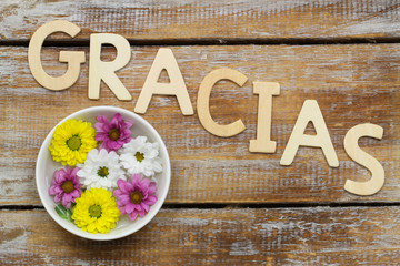 Word gracias (thank you in Spanish) and santini flowers