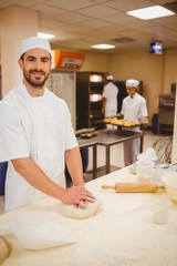 Baker kneading dough at a counter