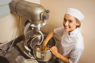 Baker using large mixer to mix dough