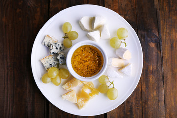 Different sort of cheese with grape and saucer