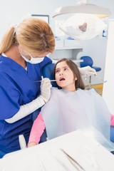 Pediatric dentist examining her young patient