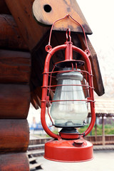 Kerosene lamp hanging on wooden house, outdoors