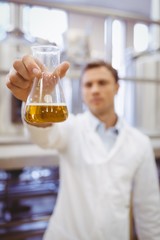 Thoughtful scientist holding a beaker