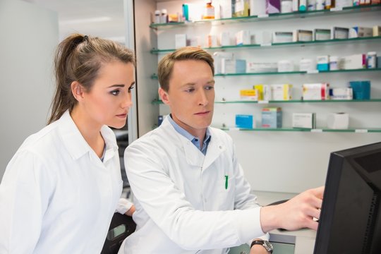 Team of pharmacists looking at computer