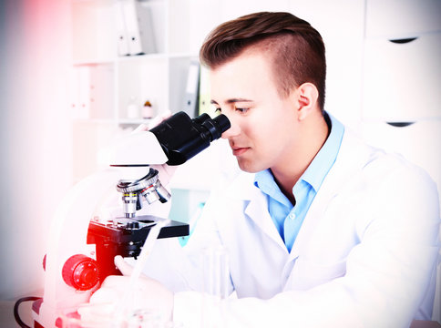 Young male researcher carrying out scientific research in lab