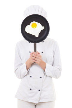 Young Woman In Chef Uniform Holding Skillet With Frying Egg Behi