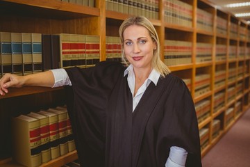 Smiling lawyer leaning on shelf