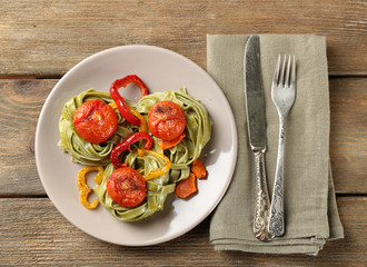 Tasty green pasta with pepper, and tomatoes