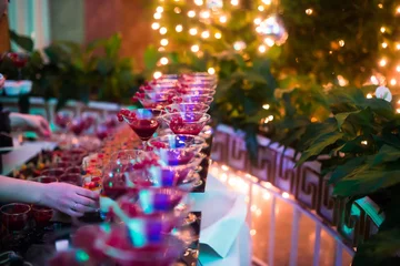 Tuinposter Line of different colored cocktails with smoke on a party © tsuguliev