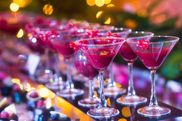 Line of different colored cocktails with smoke on a party