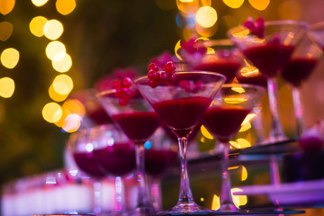 Line of different colored cocktails with smoke on a party