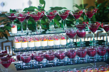 Line of different colored cocktails with smoke on a party