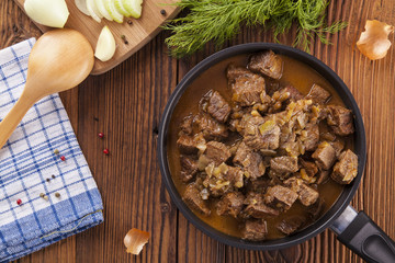 Beef stew - wooden background