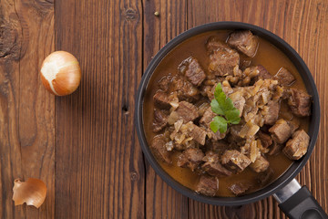 Beef stew - wooden background