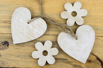 Two wooden hearts with a littles flower on old wood