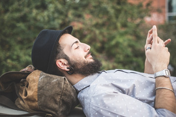 young handsome hipster gay modern man using smartphone